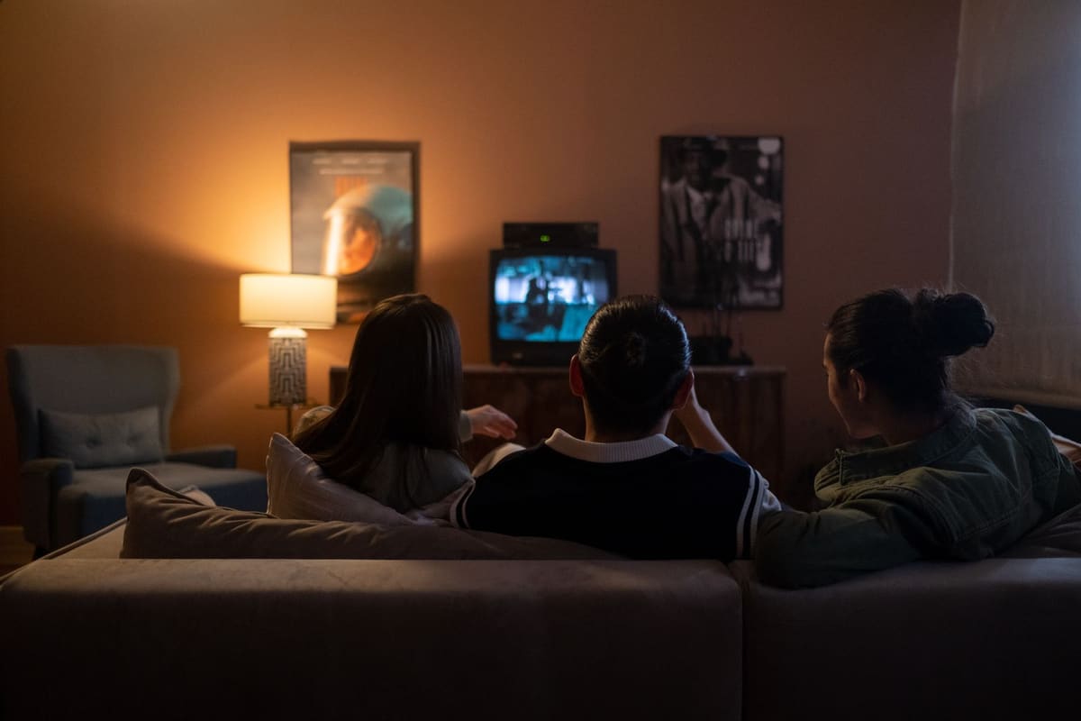 Teman-teman duduk di sofa dan menonton film