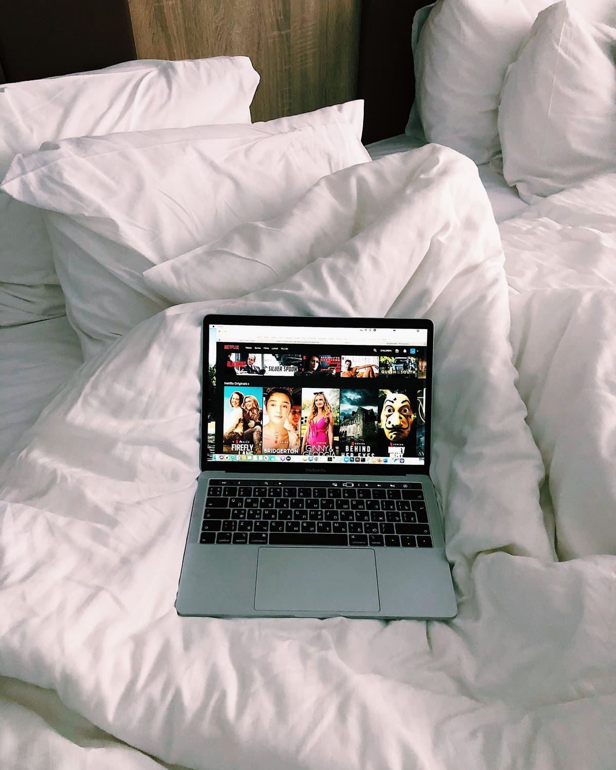 Laptop dengan film website di cozy kasur