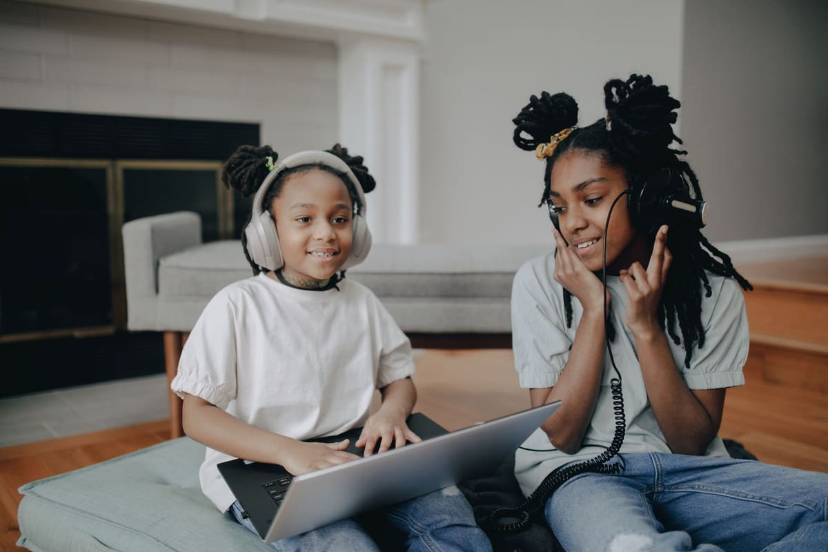 Two girls dengan laptop wearing headsets
